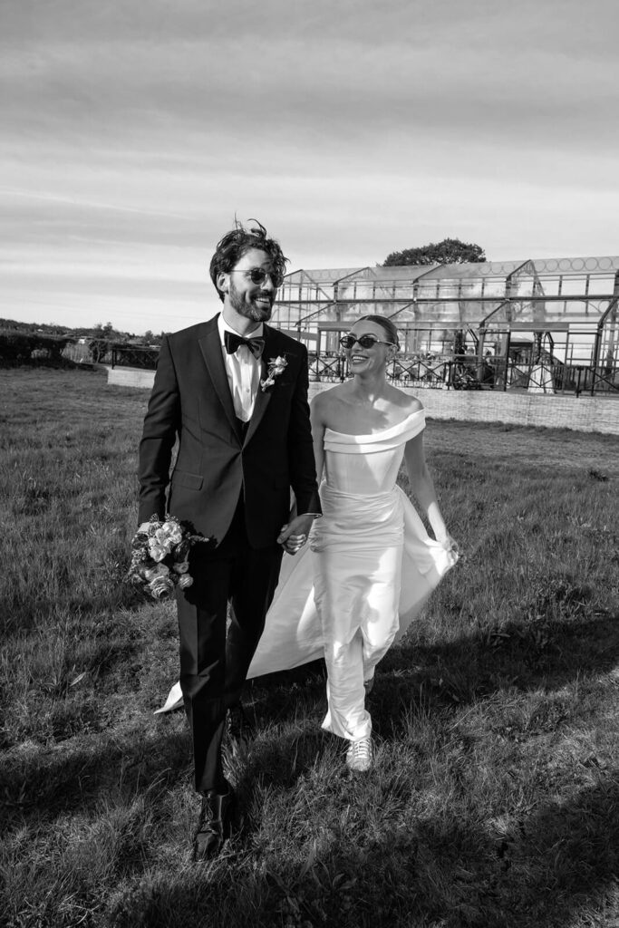 Bride and groom walking outdoors in front of Minerva Vines wedding venue | Minerva Vines wedding photographer