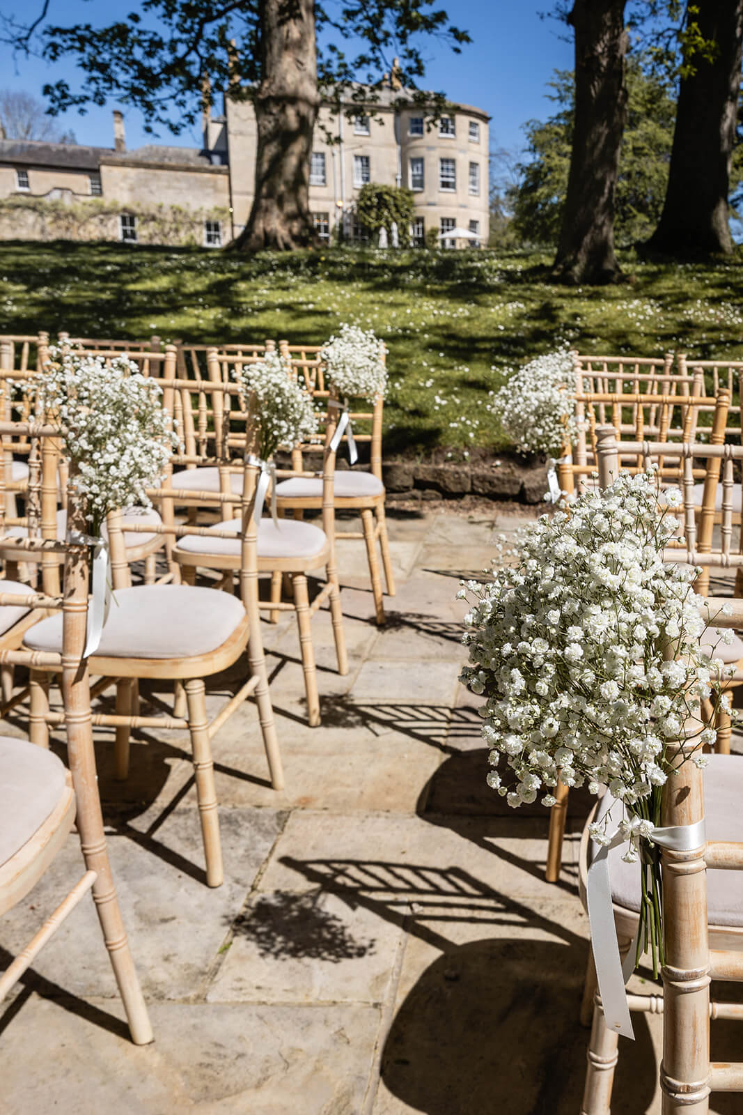 Outdoor wedding chairs with white floral arrangements for an Eastington Park wedding